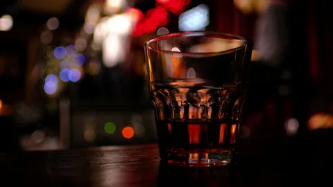 Glass with drink on table in jazz bar, blurred concert with musicians Stock Footage 297635899