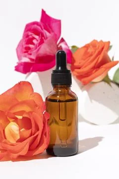Glass dropper bottle with rose flower. Stock Photos