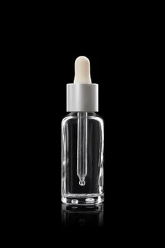 Glass dropper bottle. With a white cap on a black background Stock Photos