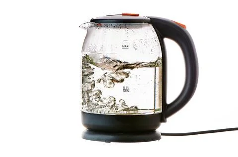 Glass electric kettle with boiling water on a white insulated background Stock Photos