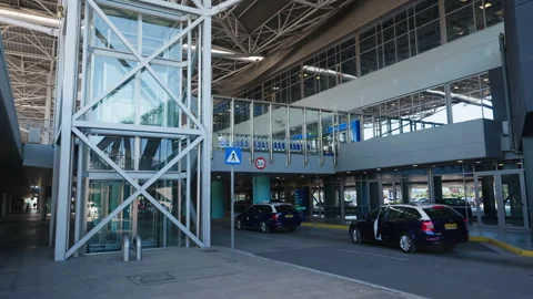 Glass Elevator and Covered Walkway at Busy Airport Entrance Stock Footage 333537840