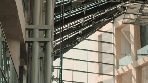 Glass Elevator Descending as Shaft Components Rise in Modern Atrium Stock Footage 342279903