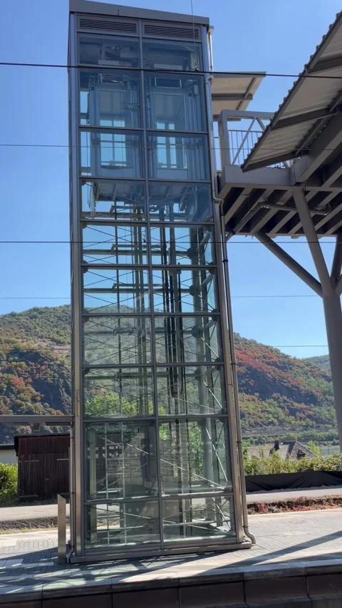 Glass elevator shaft with metal framework against blue sky Stock Footage 348281842