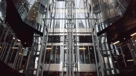A glass elevator on the side of a modern shopping mall in central London Stock Footage 113391765