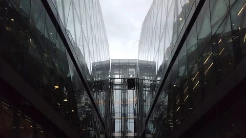 A glass elevator on the side of a modern shopping mall in central London Stock Footage 113391984