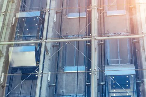 Glass elevators outside the skyscraper building, business architecture. Stockfoto's