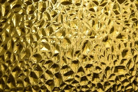 Glass with embossed wave pattern. Glass yellow or gold color. Stock Photos