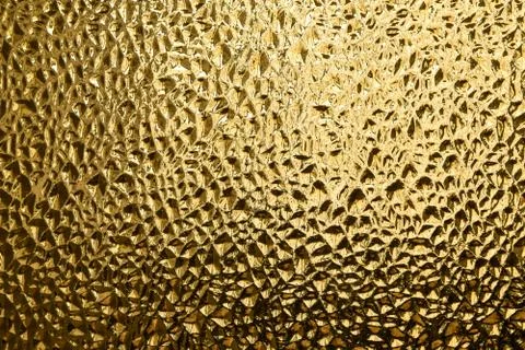 Glass with embossed wave pattern. Glass yellow or gold color. Stock Photos