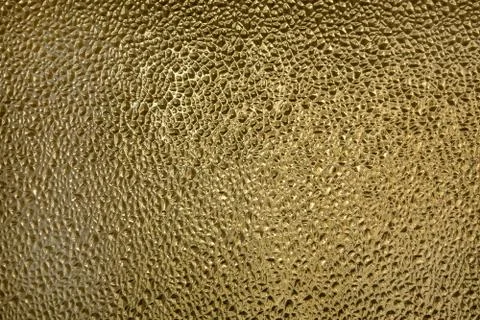 Glass with embossed wave pattern. Glass yellow or gold color. Stock Photos