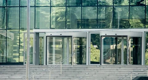 The glass entrance to or exit from a business building. Stock Footage 68597116