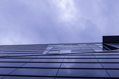 A glass facade below a cloudy sky Stock Photos