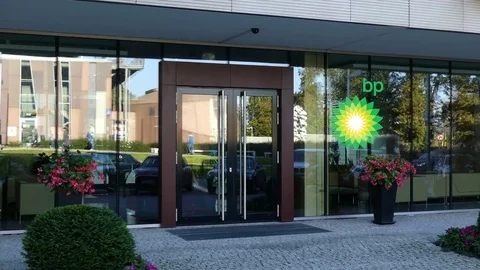 Glass facade of a modern office building with BP logo. Editorial 3D rendering Stock Footage