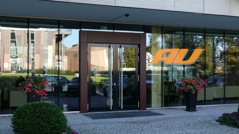 Glass facade of a modern office building with au mobile phone company logo Stock Footage