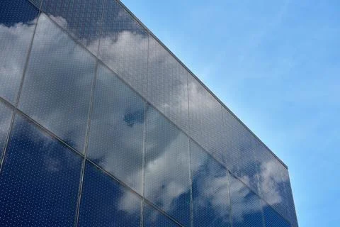 Glass facade reflecting clouds on modern building Stock Photos