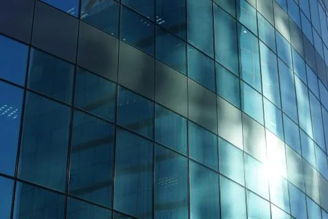 The glass facade of a skyscraper with a mirror reflection of sky windows Stock Photos