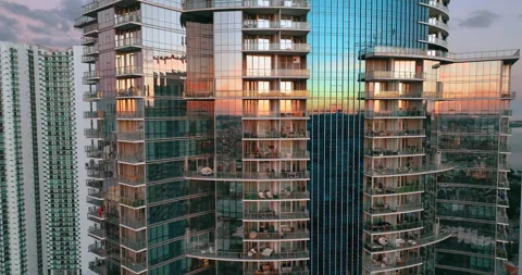 Glass facades of a skyscraper building with a reflection of a sunset landscape. Stock Footage 261844438