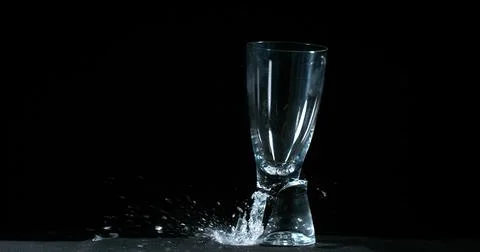 Glass Falling and exploding on Black Background Stock Photos