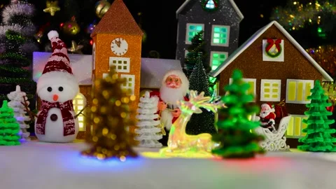 Glass figurine of a deer moves between Christmas trees and houses Stock Footage 295477645