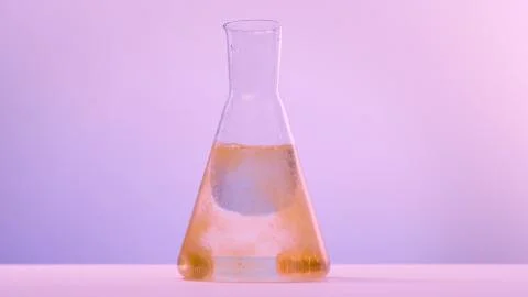 Glass Flask with An effervescent tablet dissolves is colored on orange Stock-Fotos