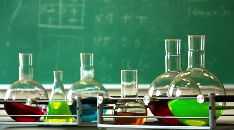 Glass flasks filled with solutions of different colors rotate on the platform Stock Footage 53851724