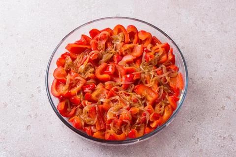Glass form with stewed chopped red sweet pepper, onion, thyme and honey on .. Stock Photos