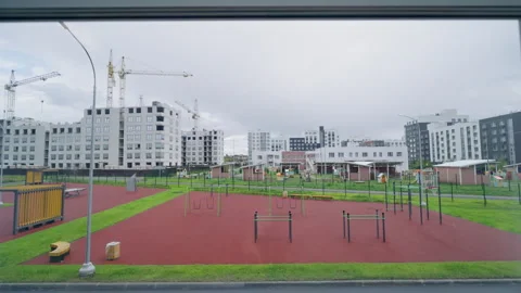 Glass frame overlooks courtyard with exercise equipment Video stock 334682978
