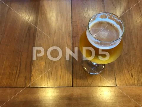 Glass of fresh cold draught beer on wood table with beautiful natural lighting Stock Photos