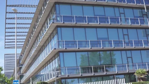 Glass-fronted commercial building with multiple balconies under sunny sky Stock Footage 336558673