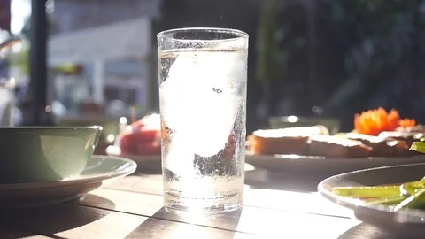 A glass glass with a clear cold of refreshing water is on the dining table in Stock Footage 88730185
