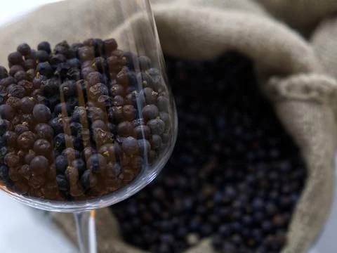 A glass goblet full of juniper berries Stock Photos