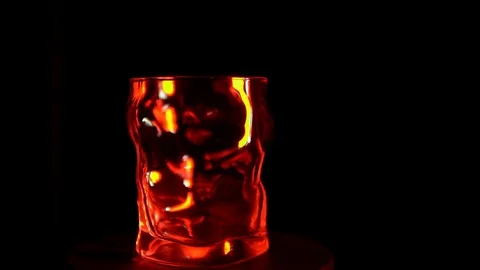 The glass goblet turns under a red backlight on a black background Stock Footage 84145696