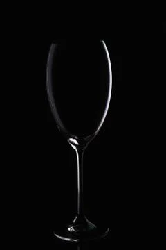 Glass goblet without wine on a thin leg stands on a mirror surface. Stock-Fotos