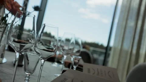 Glass goblets on a restaurant table in a large Stock Footage 308447544