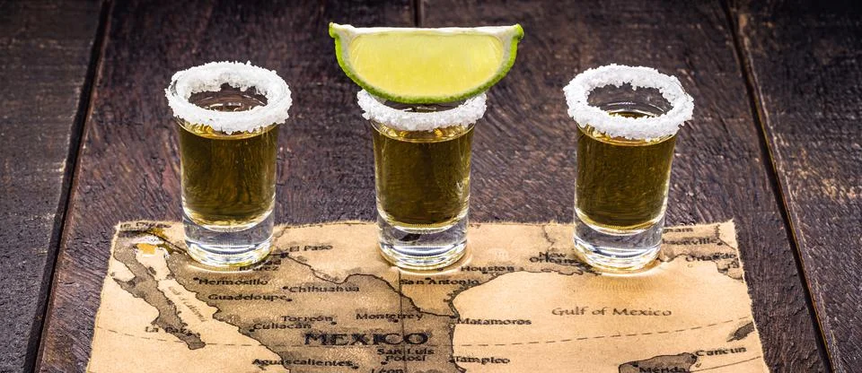 Glass of gold tequila with old mexico map in the background, image celebratio Stock Photos