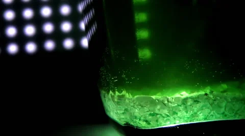 Glass with green liquid on a background of lights Stock Footage 68659328
