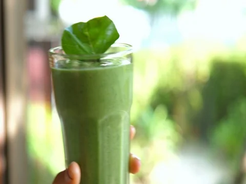 Glass of Green Spinach Smoothie In Hand For Healthy Breakfast 스톡 동영상 80424839