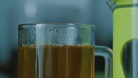In a glass with green tea falls a slice of lemon. Stock Footage 76988941