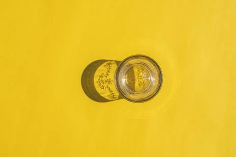 Glass with a hard shadow on a colored background Stock-Fotos