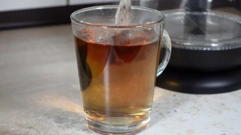 A glass of hot tea is prepared in a kitchen Vídeo Stock 295907233