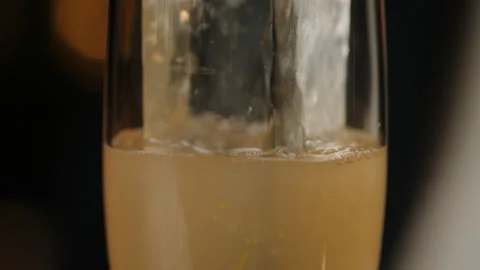Glass with ice in which the bartender pours a cocktail. Dark bar background Stock Footage 219116770