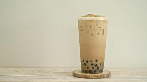Glass of iced bubble tea with tapioca pearls on a wooden table Stock Photos