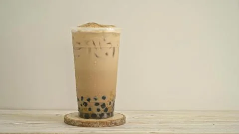 Glass of iced bubble tea with tapioca pearls on wooden table Stock Photos