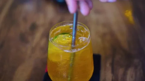 Glass of iced tea with lime, as a hand stirs the drink with a spoon. Stock Footage 238739870