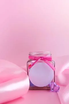 Glass jar with candy hearts inside and a pink silk ribbon Stock Photos