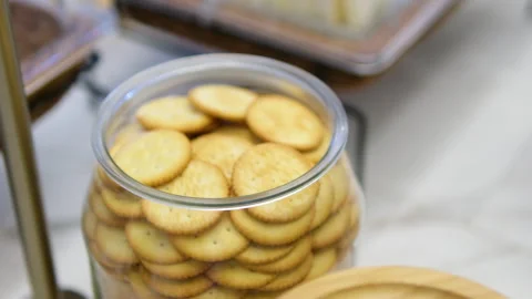 Glass jar crackers high angle shot of hand takes cracker from glass jar Video stock 313527129