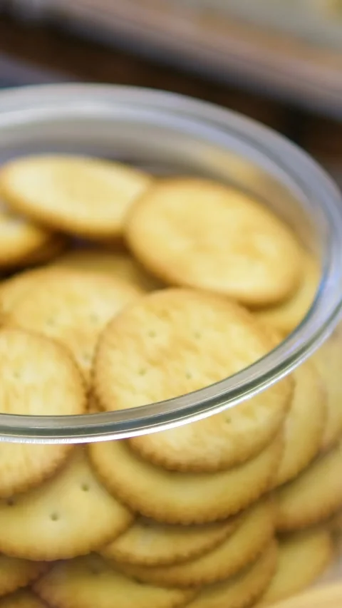 Glass jar crackers high angle shot of hand takes cracker from glass jar Stock Footage 313759381