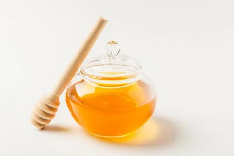 Glass jar of honey a white background Stock Photos