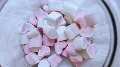 Glass jar with many marshmallows in the form of hearts on white background. Stock Footage 273816083