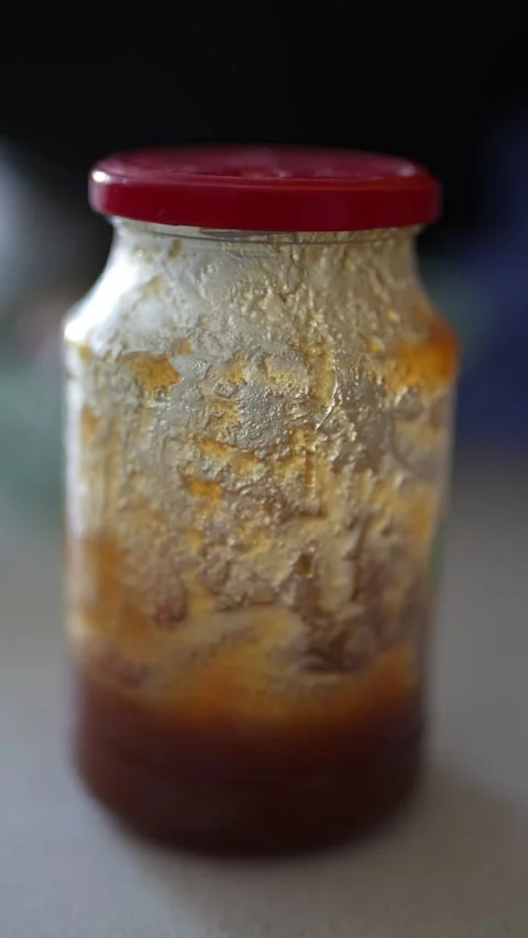 Glass jar with red lid containing thick sauce. Stock Footage 330942949