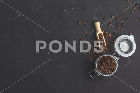 Glass jar with roasted beans and wooden scoop Stock Photos